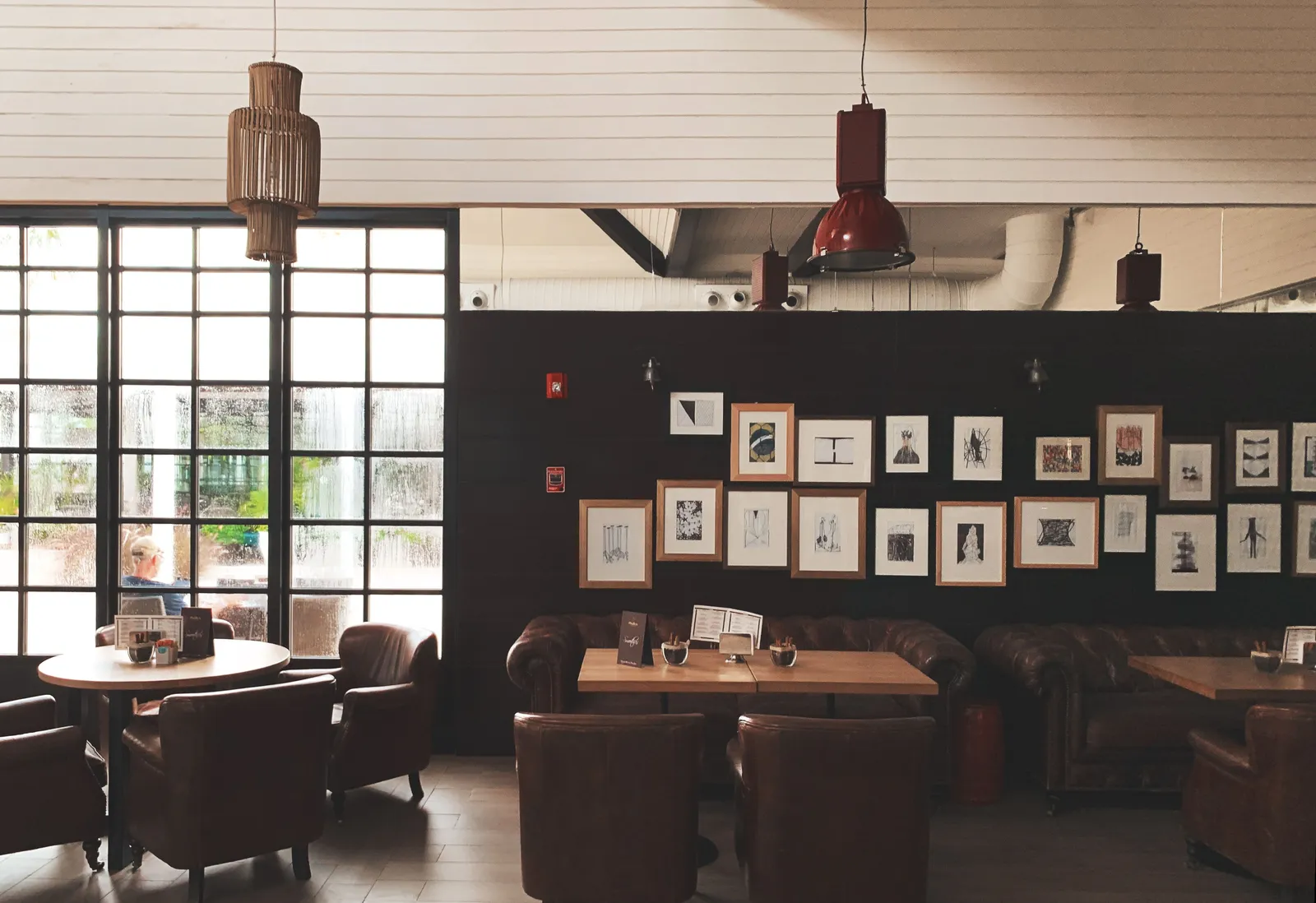 Cozy cafe interior with pendant lighting and a wall of framed art, similar to Eggspresso's Waterloo space