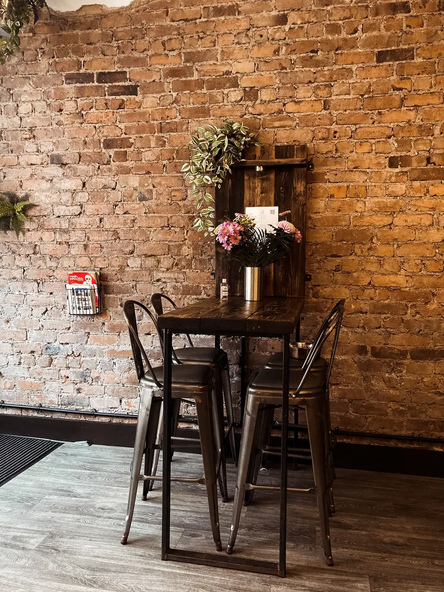 Cafe seating against an exposed brick wall