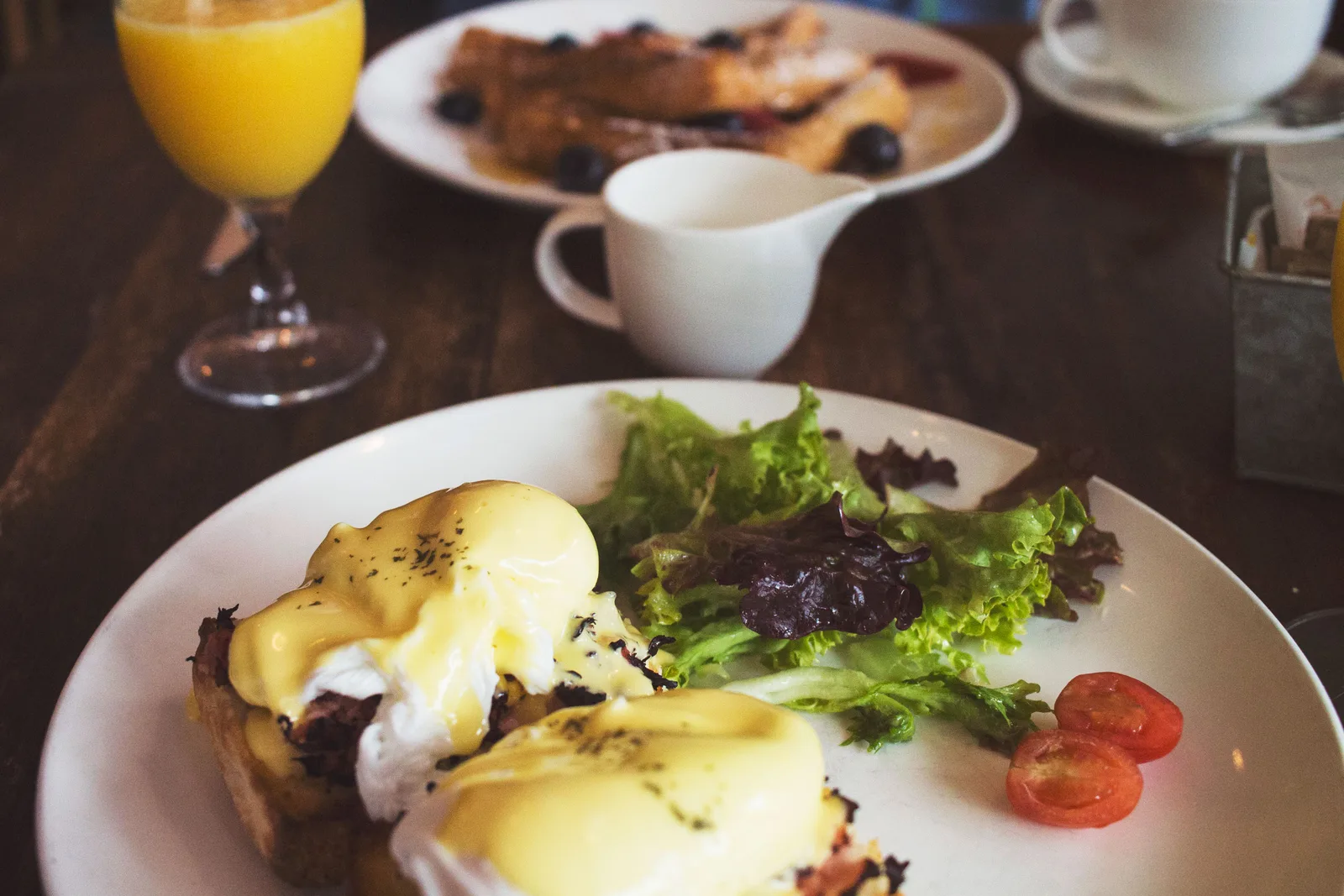Plated eggs benedict with hollandaise, served with salad